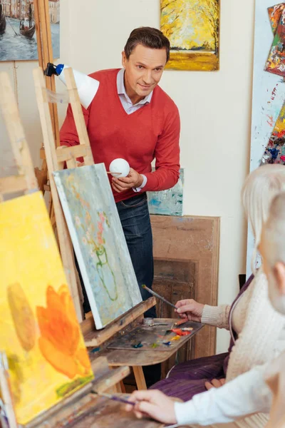 Man teaching people in painting studio — Stock Photo, Image