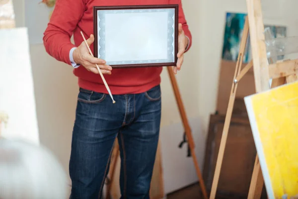 Close up of young man demonstrating a painters diploma — Stock Photo, Image