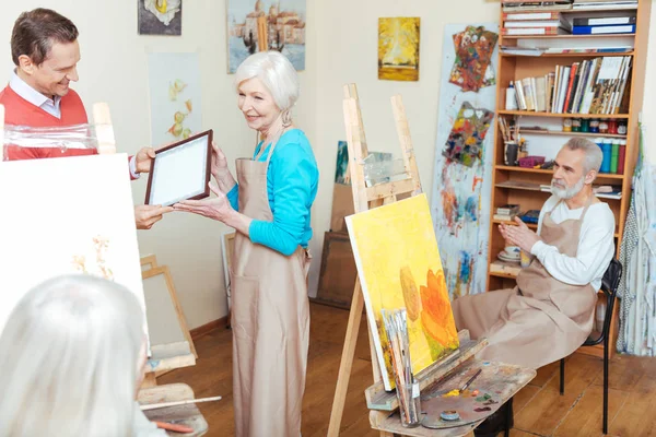 Joven hombre dando artistas diploma a la mujer —  Fotos de Stock