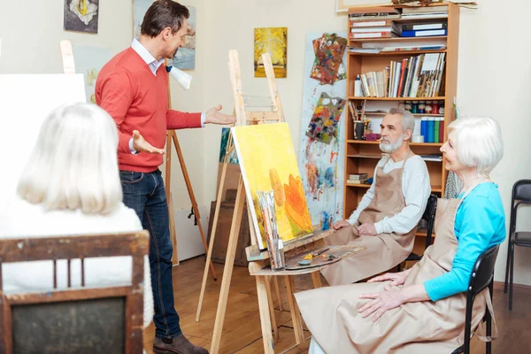 Handsome artist lecturing in painting school — Stock Photo, Image