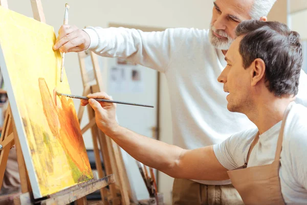Ηλικιωμένοι καλλιτέχνη ζωγραφικής με τον νεαρό συνάδελφό του. — Φωτογραφία Αρχείου