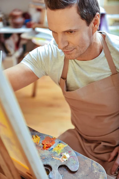 Handsome man painting picture in studio — Stock Photo, Image