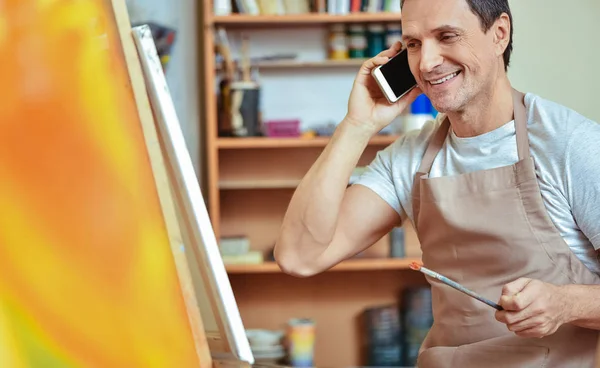 高兴的艺术家在油画工作室中使用手机 — 图库照片