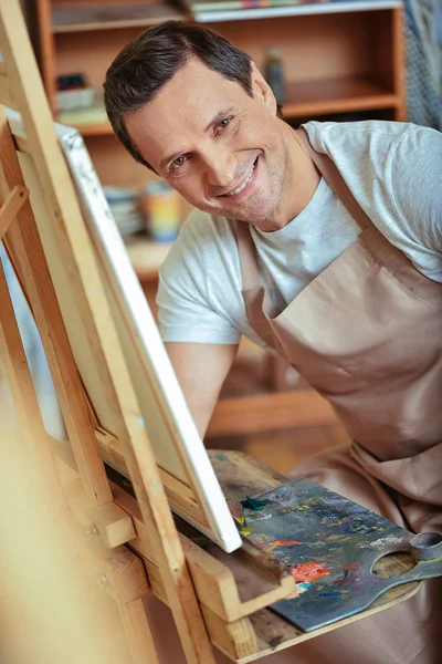 Ευτυχισμένος καλλιτέχνης θέτοντας σε εργαστήριο ζωγραφικής. — Φωτογραφία Αρχείου