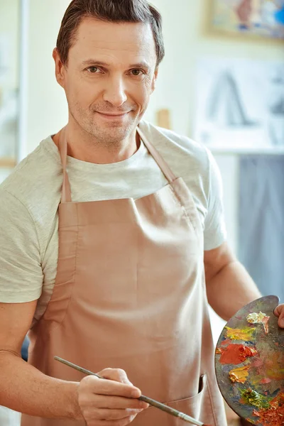 Blij man poseren met palet en penseel — Stockfoto