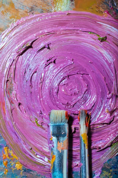 Draufsicht auf violette Farbe und Pinsel auf einer Palette — Stockfoto