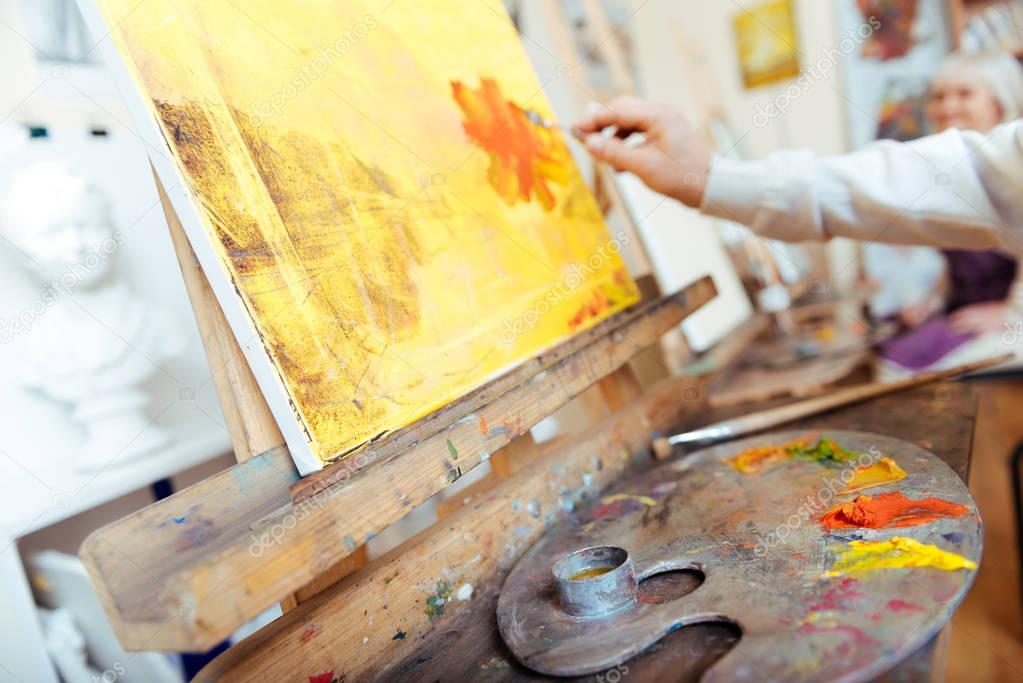 Close up of artists hands using paints and brush