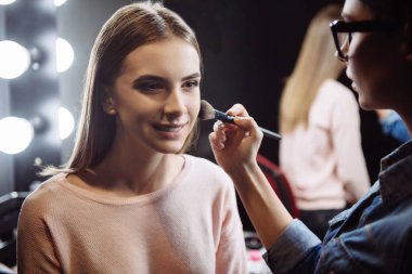 Toz yüzünde uygulanan sahip büyüleyici memnun kadın