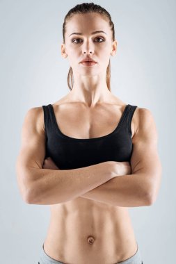 Atletik kadın gri arka plan üzerinde poz