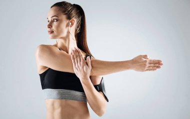 Genç kız gri bir arka plan üzerinde uzanan yapıyor