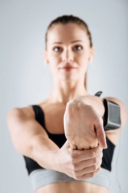 Neşeli kız kolunu gri bir arka plan üzerinde uzanan