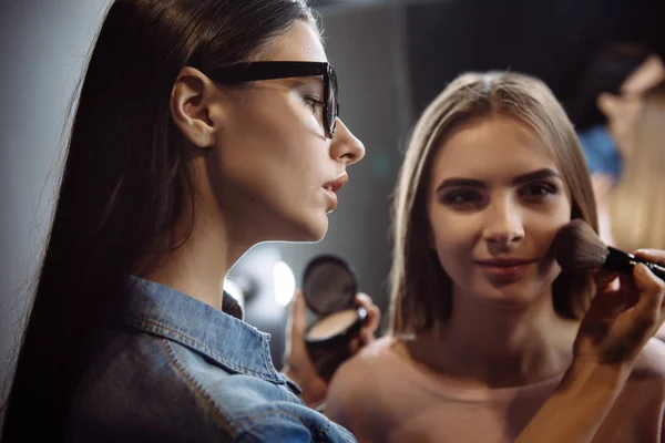 Nice concentrated makeup artist applying face powder — Stock Photo, Image