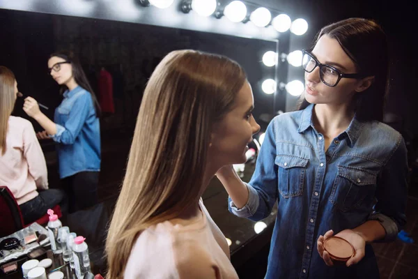 Nice positive makeup artist using face powder — Stock Photo, Image