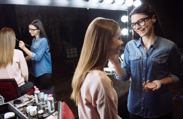 Cute happy makeup artist putting on cosmetic powder — Stock Photo, Image