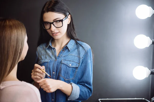 Angenehme junge Make-up-Artist mit einem Kosmetikpinsel — Stockfoto