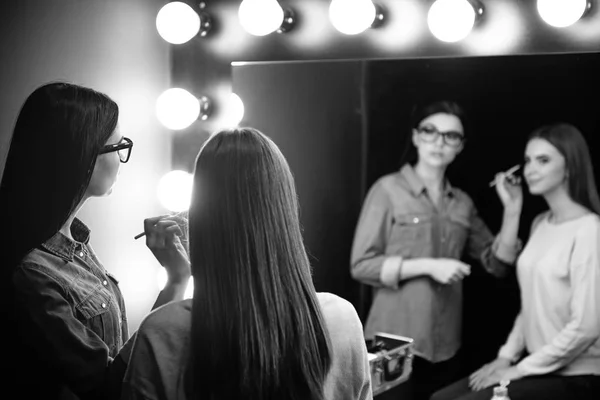 Nice attractive makeup artist looking into the mirror — Stock Photo, Image