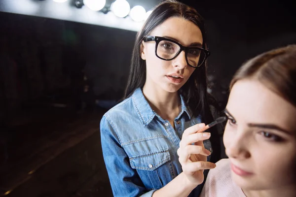Nice skillful makeup artist holding the eye brush — Stock Photo, Image