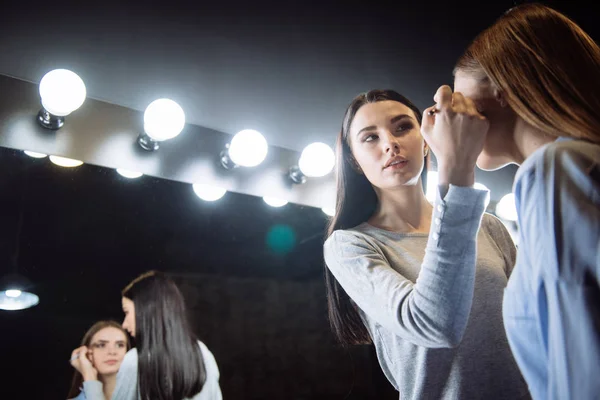 Atractivo hábil visagiste poner en maquillaje sombra de ojos — Foto de Stock