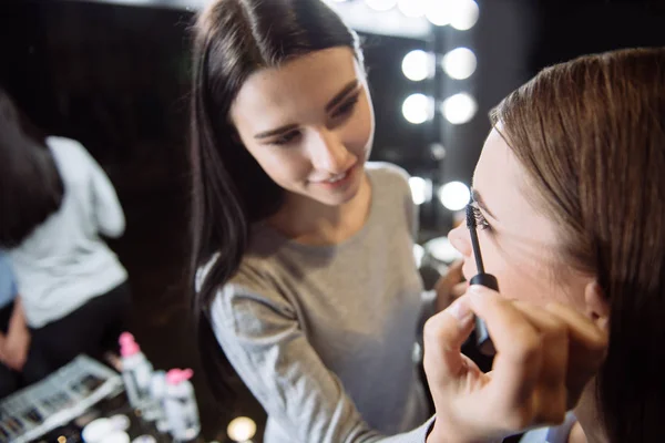 Cheerful delighted makeup artist using mascara — Stock Photo, Image