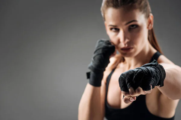 Mujer segura boxeando sobre un fondo gris — Foto de Stock