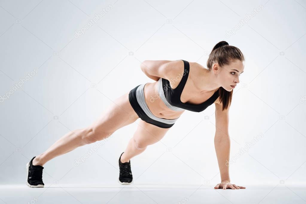 Concentrated girl standing in plank