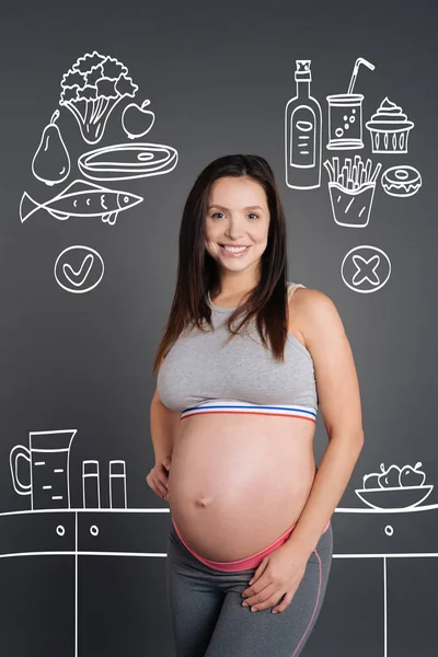 Donna incinta positiva in piedi in cucina — Foto Stock