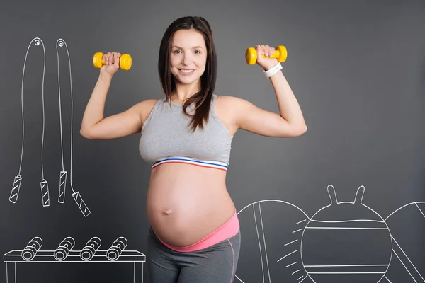 Feliz sorrindo mulher grávida fazendo exercícios esportivos . — Fotografia de Stock