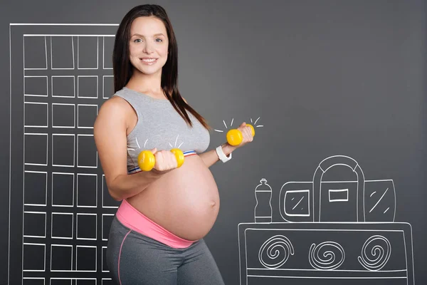 Hermosa mujer embarazada sonriente haciendo ejercicios deportivos — Foto de Stock