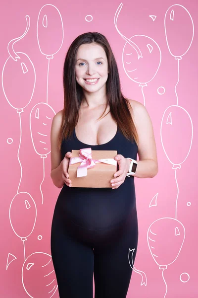 Joyeux enchanté femme enceinte tenant présent — Photo