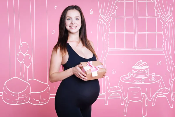 Positive pregnant woman holding present — Stock Photo, Image