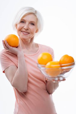 Positive delighted aged blonde demonstrating big orange