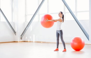 Bir fitness topu tutan neşeli genç kadın