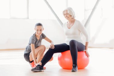 Neşeli yaşlı kadın fitness topu üzerinde oturuyordu