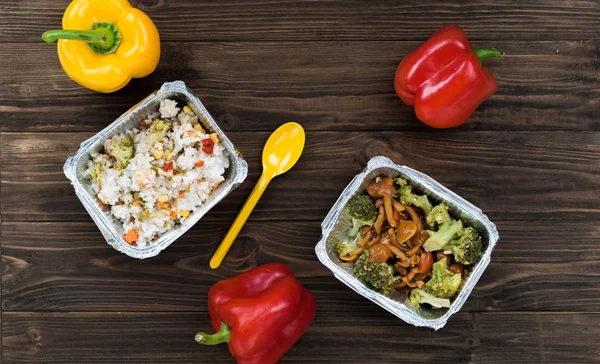 Three colorful pepper lying on the wooden table
