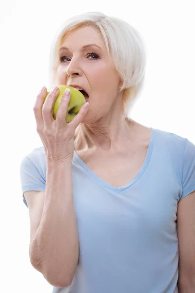 Portrét starší žena při kousání zelené jablko — Stock fotografie