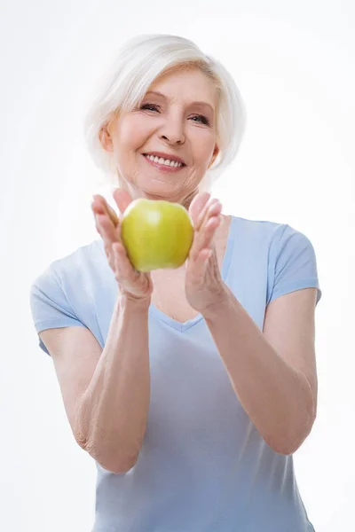 Heureuse femme souriante gardant pomme dans les deux mains — Photo