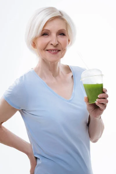 Saudável sorridente feminino aposentado mantendo vidro com suco — Fotografia de Stock