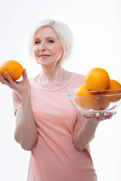 Восхитительная женщина держит апельсины в обеих руках — стоковое фото