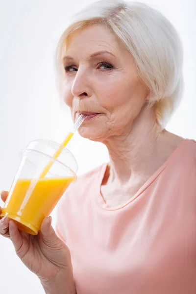 Enigmática bonita loira bebendo suco de laranja fresco — Fotografia de Stock