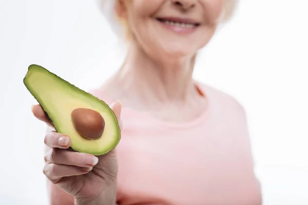 Close up of split avocado being situated in female hand — Stock Photo, Image