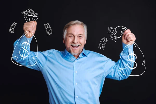 Feliz hombre alegre sosteniendo bolsas con dinero — Foto de Stock