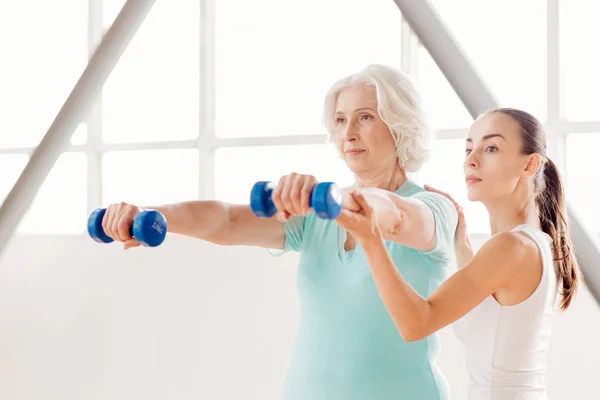 Agradable senior mujer de entrenamiento fuera con mancuernas —  Fotos de Stock