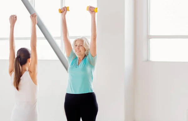 Vrolijke actieve vrouw opheffing halters — Stockfoto