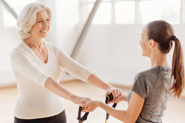 Happy aged woman holding a resistance band