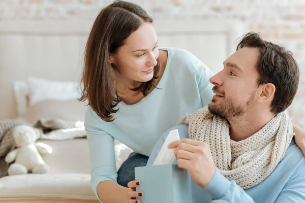 Mujer joven útil curando a su novio en casa — Foto de Stock