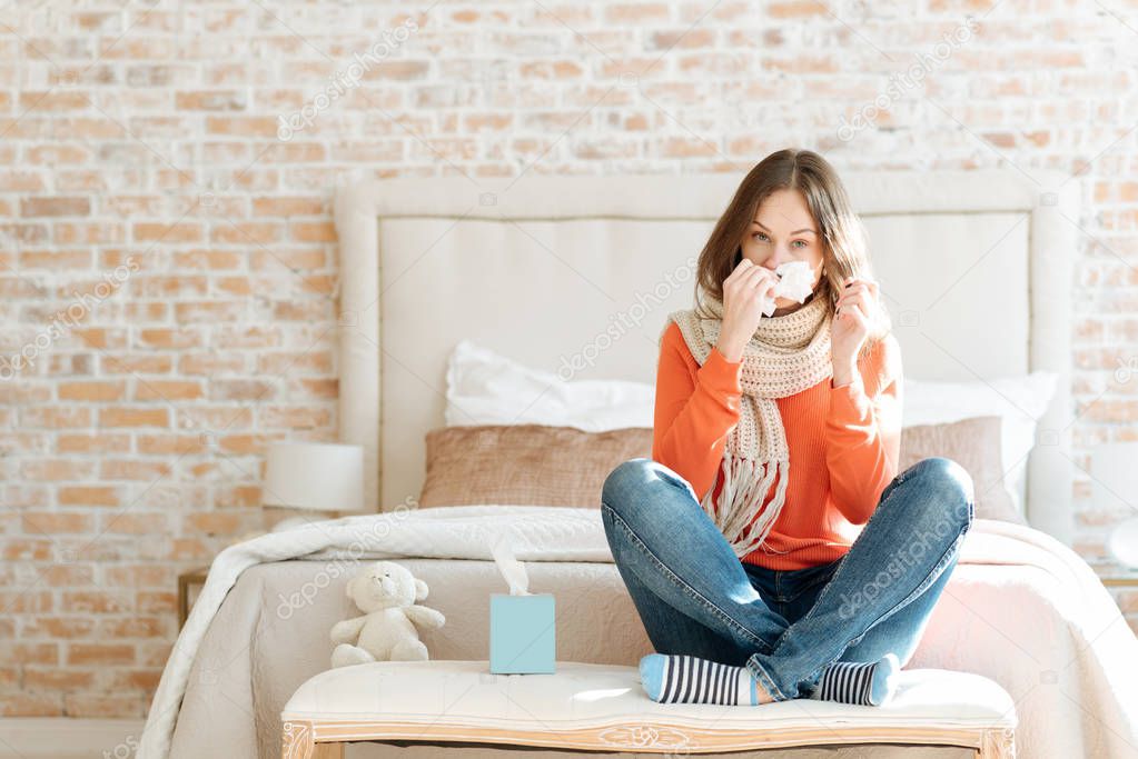 Upset young woman suffering from influenza at home