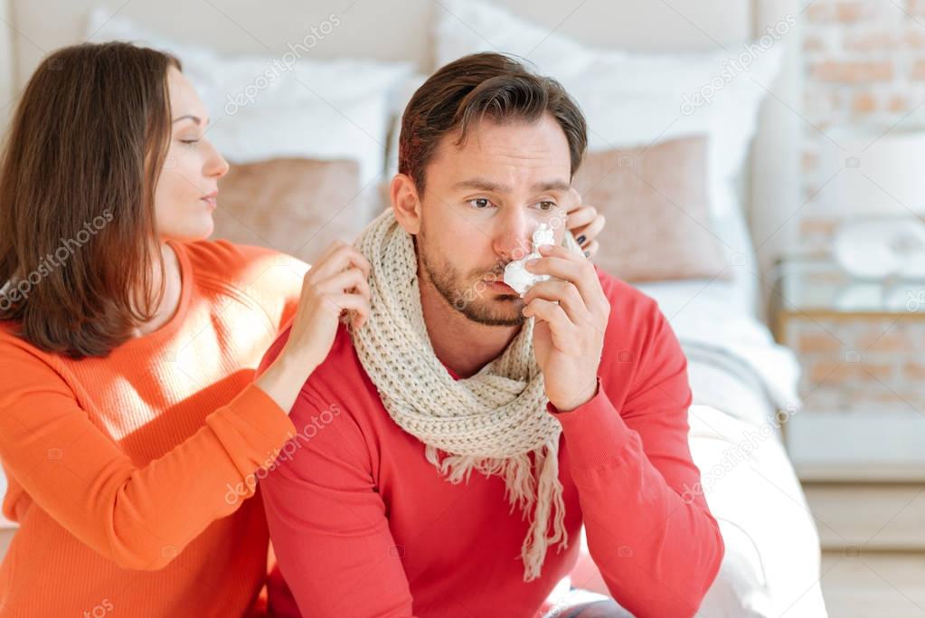 Helpful woman taking care about her boyfriend at home