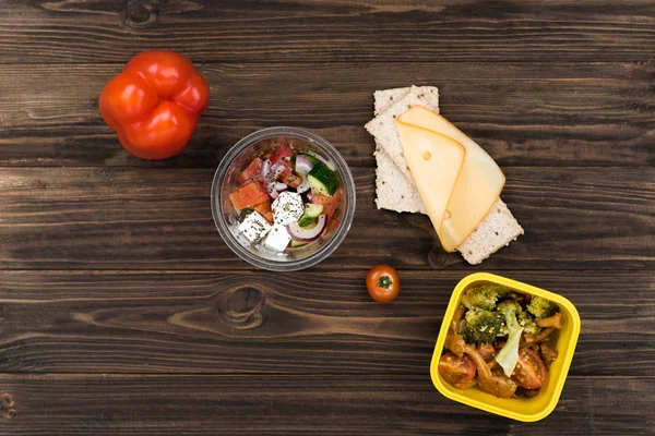 Poivron rouge mûr debout à côté d'un bol avec salade — Photo