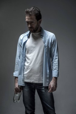 Kısır adam şişe alkol ile tutarak