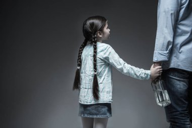 Küçük kızın babası elini tutarak arkadan görünüm